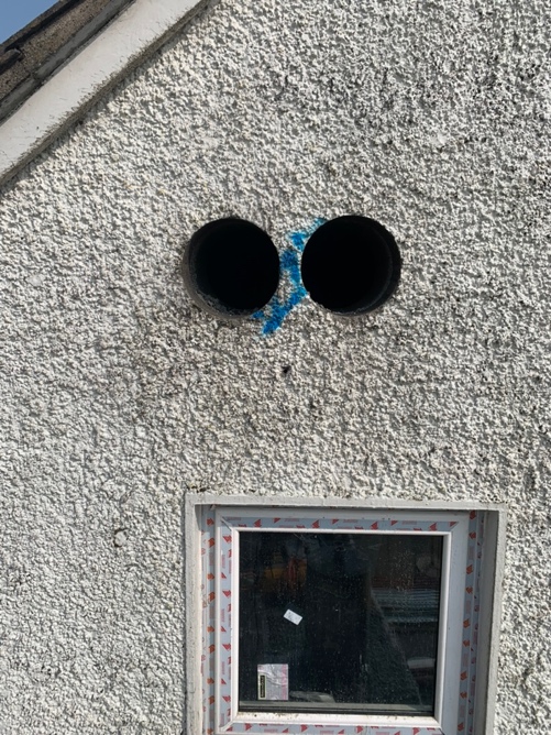 Two core holes drilled through rendered exterior wall