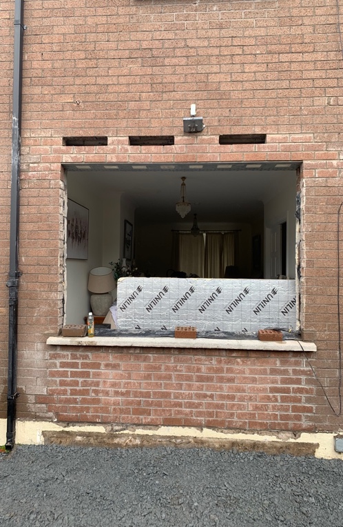 Large window opening cut through brick wall