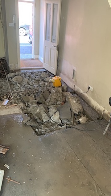 Trench cut through house floor for pipework install